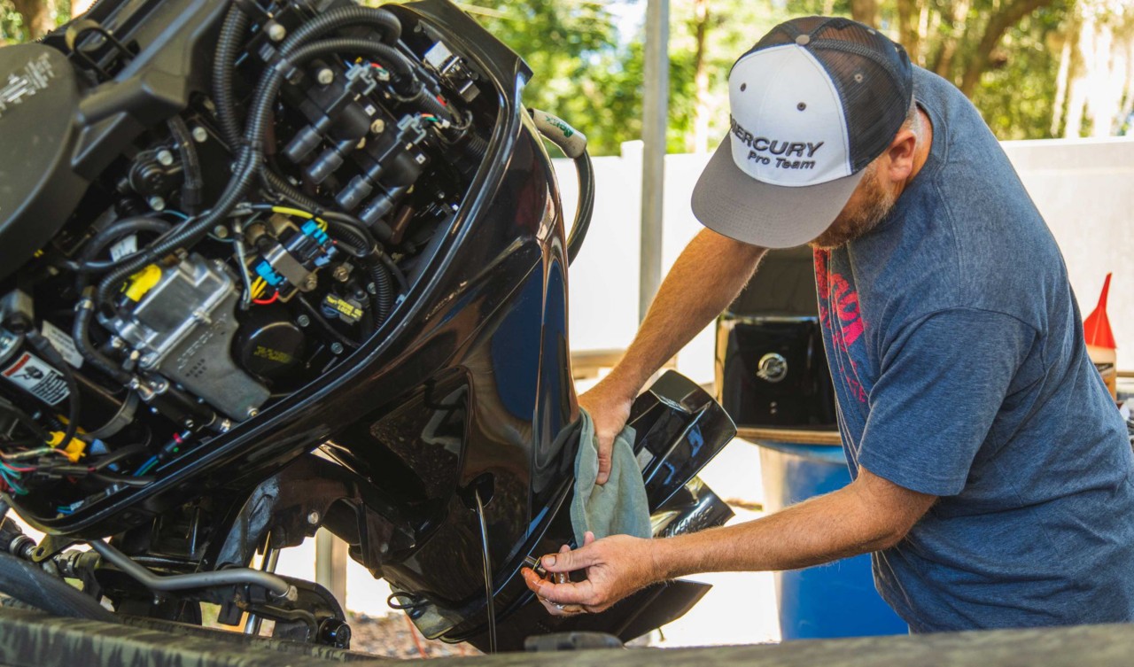 Mercury technician servicing an outboard with the cowling removed